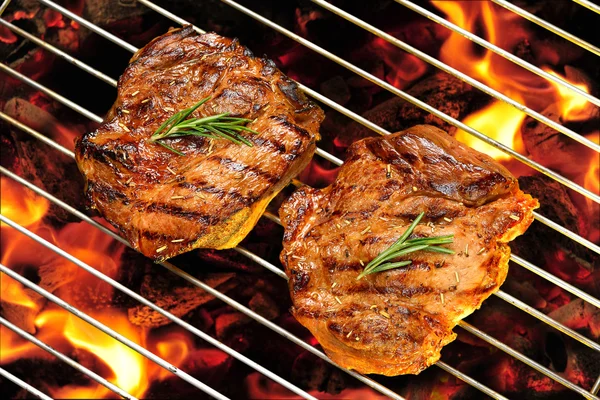 Grilled pork steak on the flaming grill — Stock Photo, Image