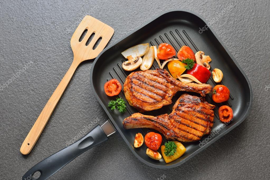 Grilled pork chops and vegetables on the grill pan Stock Photo by
