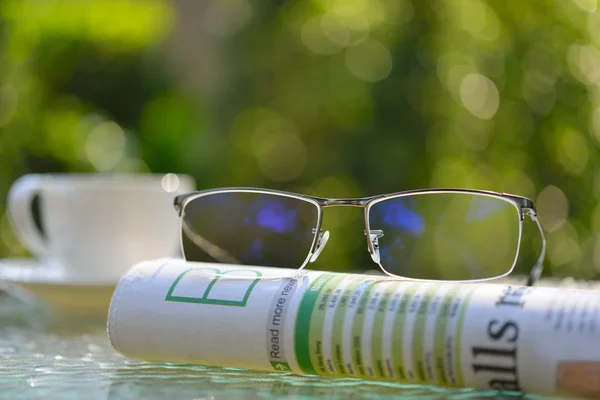 Lunettes de vue d'homme d'affaires sur le journal d'affaires dans le parc — Photo