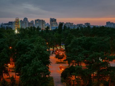 Kiev (Kiev) şehrinde inanılmaz sakin, rahatlatıcı renkli bir akşam. Binalar, gözlem çarkı ve ufuktaki kubbe kilisesi. Gökyüzüne karşı gökdelenlerin sanayi şehri.