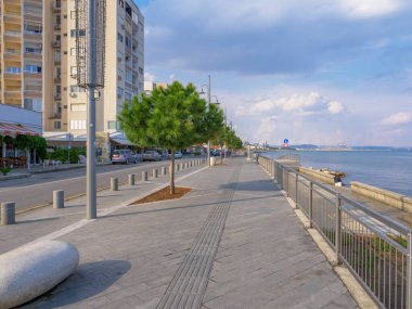 Uzun zamandır boş olan Piale Paşa, Kıbrıs 'ın Larnaka kentindeki mavi Akdeniz boyunca beton gezinti yapıyor. Suyun üzerinde bulutlu gökyüzü olan sakin bir deniz şehri..