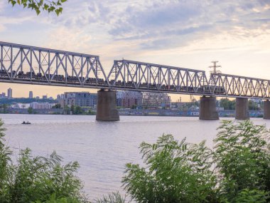 Köprünün üzerindeki Dinyeper Nehri 'nin sol kıyısından birçok yük vagonuyla birlikte uzun yük köprüsüne bakın. Kyiv şehir hayatı.