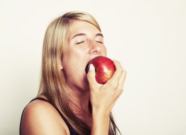 Kadın elmayı ısırıyor.