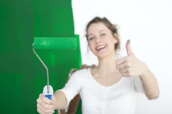 Kvinna med paint roller tummen upp — Stockfoto