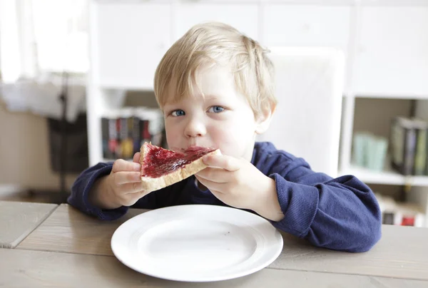 Boy eating bread and jam — Stock Photo, Image
