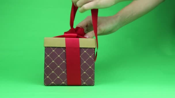 Распаковываю Подарок Крупным Планом Коробка Красным Бантом Изолированный Зеленом Фоне — стоковое видео