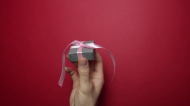 Erkek el, kırmızı arka plandaki bir kadına hediye gönderir. Uzayı kopyala 14 Şubat 'ta. Sevgililer Günü.