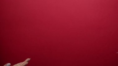 Erkek el, kırmızı arka plandaki bir kadına hediye gönderir..