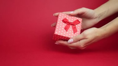 Sevgililer Günü. Kırmızı arka planda çok renkli kalpler düşüyor.