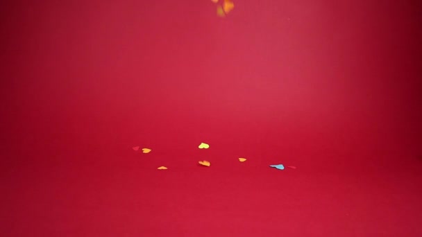 Día de San Valentín. Corazones multicolores cayendo sobre un fondo rojo. — Vídeos de Stock