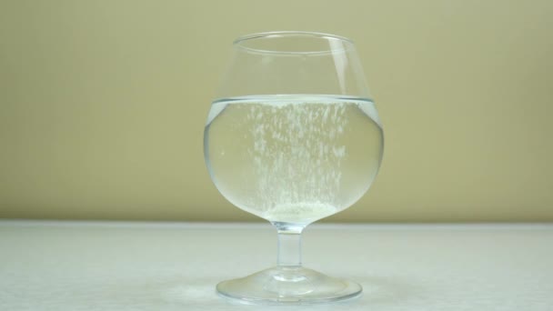 Água colorida carbonatada em um vidro transparente em um fundo claro. — Vídeo de Stock