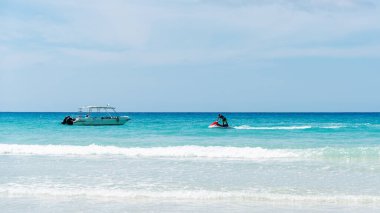 Motorlu tekne ve jet ski ile okyanus manzarası. Yaz tatili aktiviteleri.