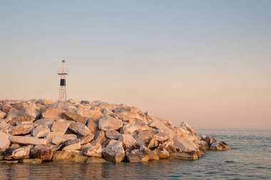 Gün batımında deniz feneri dalga kırıcılarda