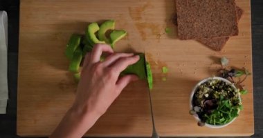 Tahta kesme tahtasının üzerinde taze olgun avokado dilimleme manzarası 