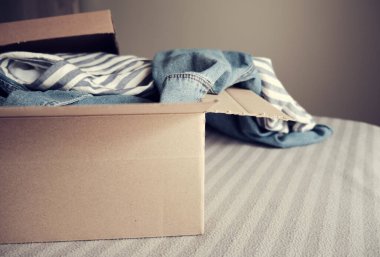 İçinde giysiler olan bir kart kutusu. Bağış Konsepti veya İkinci El