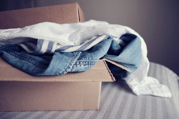 İçinde giysiler olan bir kart kutusu. Bağış Konsepti veya İkinci El
