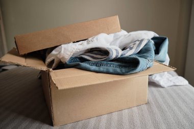 İçinde giysiler olan bir kart kutusu. Bağış Konsepti veya İkinci El