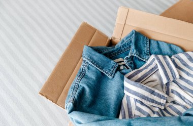İçinde giysiler olan kart kutusundan genel manzara. Sürdürülebilir moda, kullanılmış giysileri yeniden satma