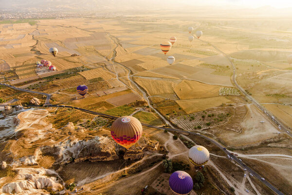 Aerial view of valley with hot air balloons flying in Cappadocia, Turkey. 