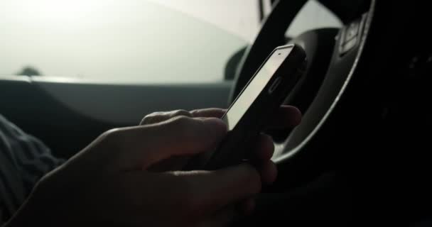 車に座っている間にスマートフォンに入力する男を閉じます. — ストック動画