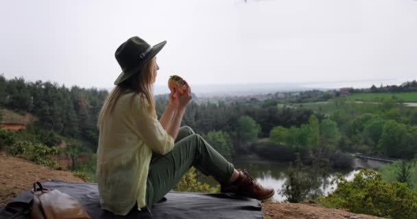 Turista Menina Chapéu Sentado Uma Encosta Comendo Admirando Lagoa Paisagem — Vídeo de Stock