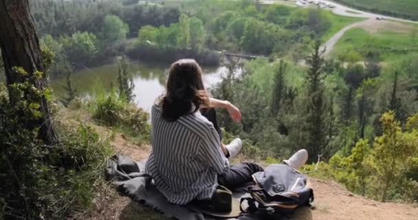 Turista Homem Chapéu Sentado Uma Encosta Admirando Lagoa Paisagem Floresta — Vídeo de Stock