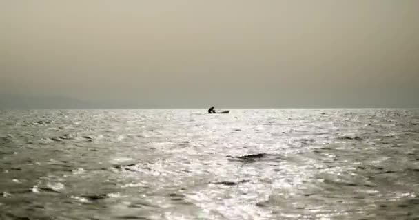 Silhouette férfi próbál felkelni a szörfdeszka. — Stock videók