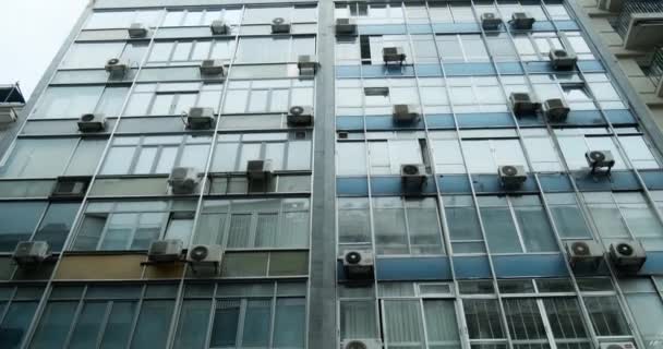 Låg vinkel syn på stadsbyggnad fasad med många luftkonditionering. — Stockvideo