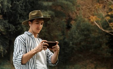 Adam elinde telefonla ekrana bakıyor. Sosyal medya videosu içeriğini izliyor.