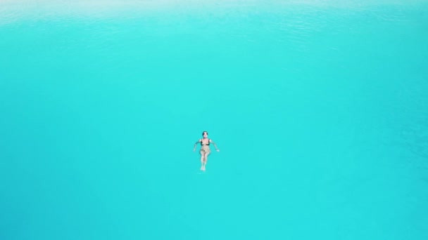 Drone uitzicht op vrouw zwemmen in de blauwe zee. — Stockvideo