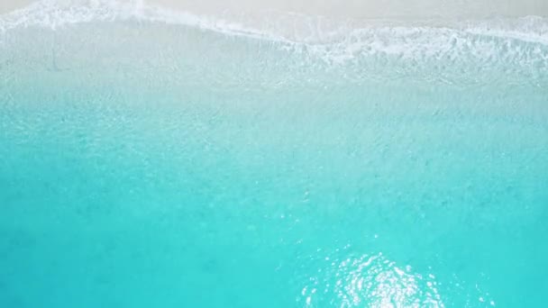 Pohled shora dolů na pláž s modrým mořem a bílým pískem. — Stock video