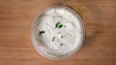 Maydanoz parçacıklarının görüntüsü krema sosuna düşer.