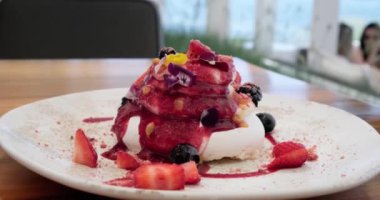 Taze böğürtlenli gurme Pavlova pastası ve krem şanti katmanları bir tabakta servis ediliyor, mükemmel yaz tatlısı.