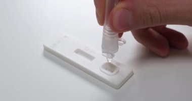 Geniz temizleme çubuğuyla hızlı antijen testi yapmak, tampon kesesinden tüpe sıvı dökmek, ellerini kapat..