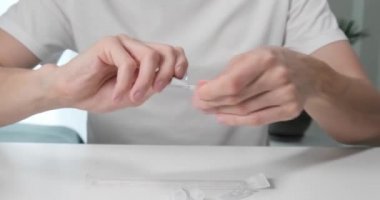 Selanik, Yunanistan - 1 Haziran 2021: Covid-19 hızlı antijen test kitini evde açan adam, Coronavirus kendi kendine test seti.