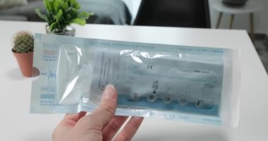 Selanik, Yunanistan - 1 Haziran 2021: Covid-19 hızlı antijen test kiti ile el ele tutuşmanın ilk görüşü.