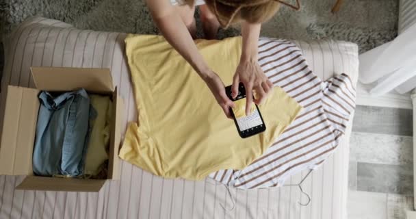 Женщина Фотографирует Подержанную Рубашку Продажи Интернете Перепродажи Подержанной Одежды Донорской — стоковое видео