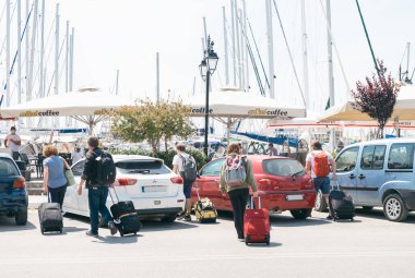 Lefkada, Yunanistan - 8 Haziran 2021: Turistler Lefkada şehrine geldi, bavulları ve bavullarıyla sokakta yürüdüler. Yunanistan 'da 2021 Yaz Turizm Sezonu.