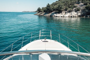 Güzel bir turkuaz denizde yelken açan bir yatın çarpıcı manzarası.