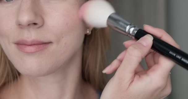 Glimlachende vrouw aanbrengen blush met gezicht borstel. — Stockvideo