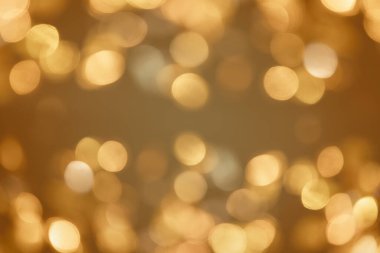 Altın ışıklı Noel arkaplanı. Soyut ışıltılı parlak arkaplan Bokeh odaklı altın ışıklarla