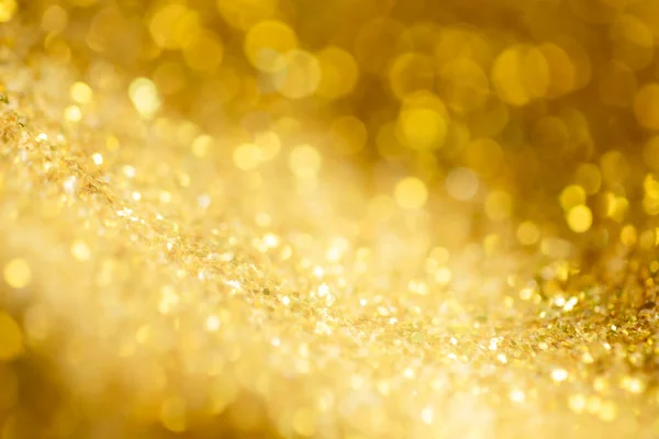 Gold light Festive Christmas background. Abstract twinkled bright background with bokeh defocused golden lights