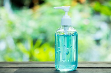 Alkol jeli şişesi ya da antibakteri ve virüs için el dezenfektanları. Doğal ışığın bulanık arka planında ve rahat görünmesi için boş alanda..