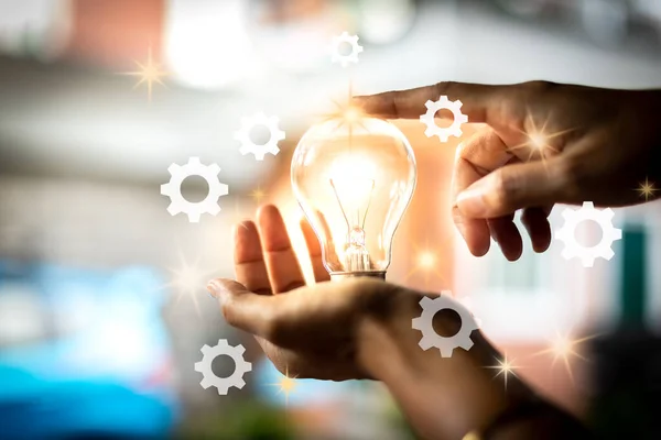 A hand with a light bulb Is a creative idea of innovation Abstract the concept of business success