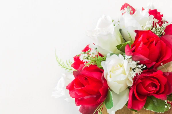 Rosas rojas y rosas blancas artificiales sobre un fondo blanco — Foto de Stock