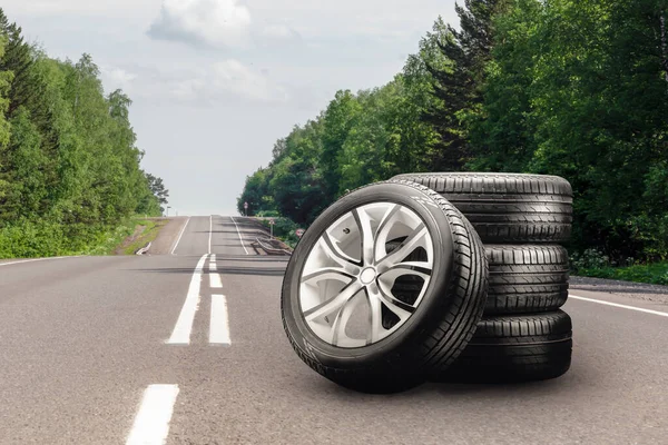 summer tires and alloy wheels set on an asphalt road. tire change season, auto trade, copy space , auto tuning and tire service