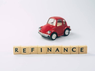 Beyaz arka planda oyuncak arabalı küple yazılmış REFINANCE sözcüğü, nakit konsepti ile takas arabası