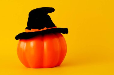 Sarı arka planda siyah şapkalı turuncu balkabağı ile Cadılar Bayramı konsepti metin için boşluk kopyala