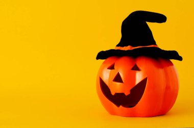 Cadılar Bayramı balkabağı nesneleri sarı arka planda siyah şapkalı ve metin için kopya alanı olan nesneler