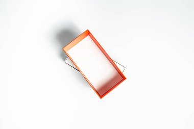 Beyaz arka planda turuncu-kırmızı kutu kapaklı karton kutuyu aç